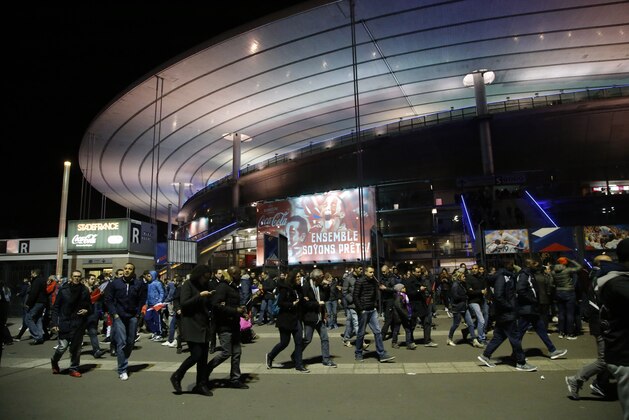 People leave the Stade de France stadium after the international friendly soccer France against Germany, Friday, Nov. 13, 2015 in Saint Denis, outside Paris. Two police officials say at least 11 people have been killed in shootouts and other violence around Paris. Police have reported shootouts in at least two restaurants in Paris. At least two explosions have been heard near the Stade de France stadium, and French media is reporting of a hostage-taking in the capital. (AP Photo/Michel Euler)