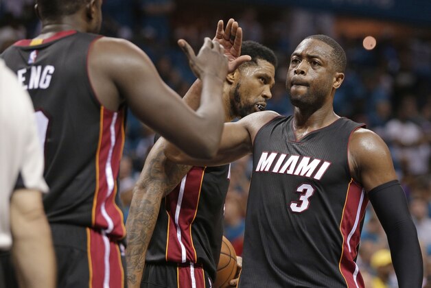 FILE - In this April 29, 2016, file photo, Miami Heat's Dwyane Wade (3) gives a high-five to Luol Deng after Game 6 of an NBA basketball playoffs first-round series against the Charlotte Hornets in Charlotte, N.C. Wade still has every hope of finishing his NBA career in the same manner that it began, wearing a Heat uniform. That's the good news for Heat fans.  Now comes the tough part, that being Wade and the team figuring out how to make that a reality. (AP Photo/Chuck Burton, File)