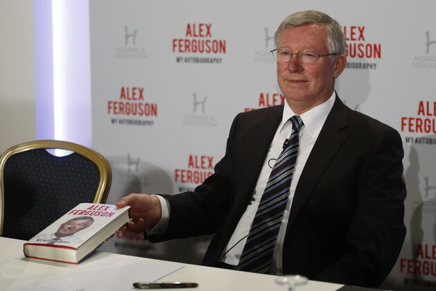 Former Manchester United manager Sir Alex Ferguson poses with his book 'My Autobiography' during a press conference in central London, Tuesday, Oct. 22, 2013. (AP Photo/Sang Tan)
