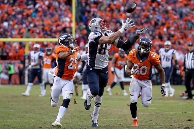 DENVER, CO - JANUARY 24:  Rob Gronkowski #87 of the New England Patriots makes a catch on fourth down against Chris Harris #25 and  Josh Bush #20 of the Denver Broncos in the fourth quarter in the AFC Championship game at Sports Authority Field at Mile High on January 24, 2016 in Denver, Colorado.  (Photo by Doug Pensinger/Getty Images)