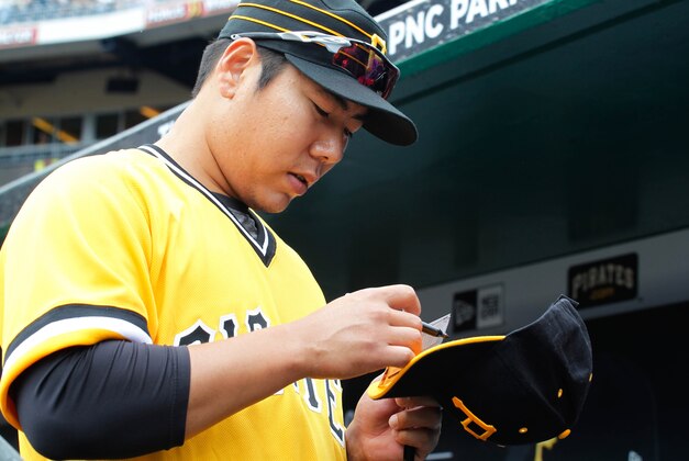 Jun 5, 2016; Pittsburgh, PA, USA; Pittsburgh Pirates third baseman Jung Ho Kang (27) signs autographs in the dugout before playing the Los Angeles Angels at PNC Park. The Angels won 5-4. Mandatory Credit: Charles LeClaire-USA TODAY Sports