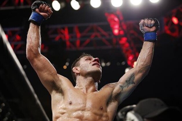 FILE - In this March 15, 2015, file photo, Rafael dos Anjos celebrates after winning the men's lightweight mixed martial arts title bout against Anthony Pettis at UFC 185 in Dallas. Anjos defends his UFC lightweight title belt against Donald Cerrone in Orlando, Fla., on Saturday, Dec. 19, in a meeting of two fighters who traveled lengthy roads to their showdown. (AP Photo/Brandon Wade, File)