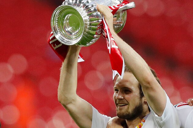 Manchester United's Dutch midfielder Daley Blind (L) holds up the trophy as he celebrates on the pitch after their victory after extra time in the English FA Cup final football match between Crystal Palace and Manchester United at Wembley stadium in London on May 21, 2016.
Manchester United won the game 2-1, after extra time. / AFP / Adrian DENNIS / NOT FOR MARKETING OR ADVERTISING USE / RESTRICTED TO EDITORIAL USE        (Photo credit should read ADRIAN DENNIS/AFP/Getty Images)