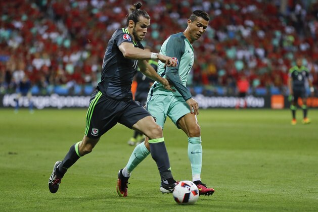 Wales' Gareth Bale, left, and Portugal's Cristiano Ronaldo compete for the ball during the Euro 2016 semifinal soccer match between Portugal and Wales, at the Grand Stade in Decines-Charpieu, near Lyon, France, Wednesday, July 6, 2016. (AP Photo/Frank Augstein)