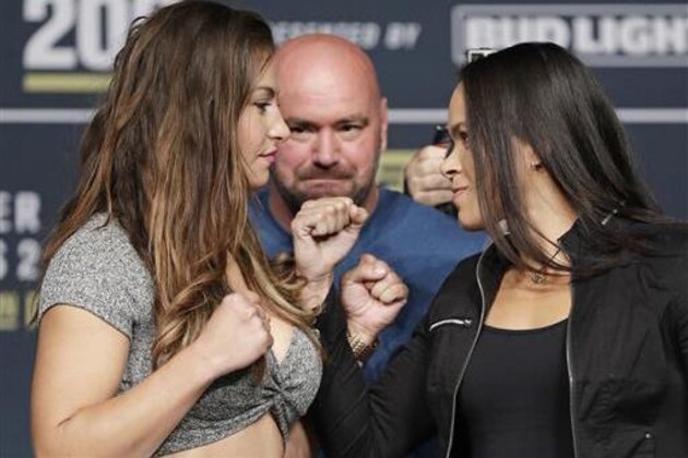 Miesha Tate, left, and Amanda Nunes pose for photographers during a UFC 200 mixed martial arts news conference, Wednesday, July 6, 2016, in Las Vegas. The two are scheduled to fight in a women's bantamweight championship fight at UFC 200 on Saturday. (AP Photo/John Locher)