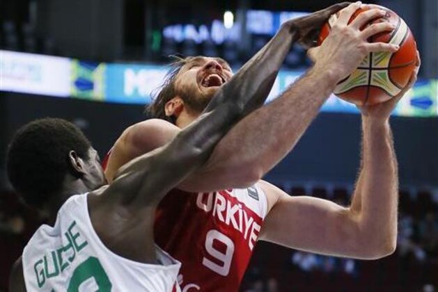 Turkey's Semih Erden, background is fouled by Senegal's Serigne Gueye in the Group A FIBA Olympic Qualifying basketball match Thursday, July 7, 2016 at the Mall of Asia Arena in suburban Pasay city south of Manila, Philippines.Turkey won 68-62. (AP Photo/Bullit Marquez)