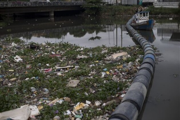In this Nov. 5, 2015 photo, trash collects against floating waste barriers in the Meriti River, which flows into the Guanabara Bay, in Rio de Janeiro, Brazil. Rio’s waterways, like those of many developing nations, are extremely contaminated because most of the city’s sewage is not treated, let alone collected. Massive amounts of it flow straight into Guanabara Bay. (AP Photo/Silvia Izquierdo)