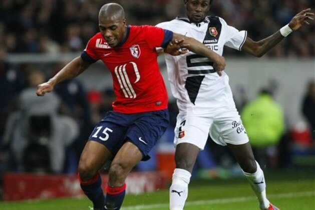 Lille's Djibril Sidibe, and Rennes' Jonathan Pitroipa challenge for the ball  during their French League one soccer match at the Lille Metropole stadium, in Villeneuve d'Ascq, northern France, Friday, Jan. 24, 2014. (AP Photo/Michel Spingler)