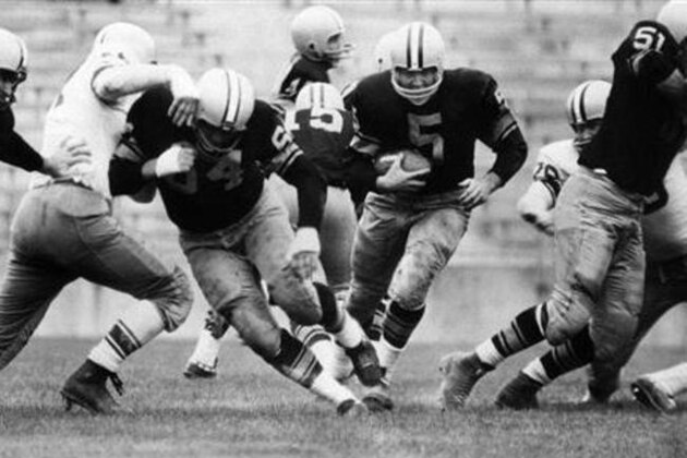 FILE - In this Aug. 10, 1959 file photo, Paul Hornung (5) of the Green Bay Packers goes through the line in an inter-squad game in Green Bay, Wis. Pro football Hall of Famer and former Heisman Trophy winner Hornung on Thursday, July 7, 2016, sued equipment manufacturer Riddell Inc., saying their football helmets that he wore during his professional career in the 1950 and ‘60s failed to protect him from brain injury. (AP Photo, File)