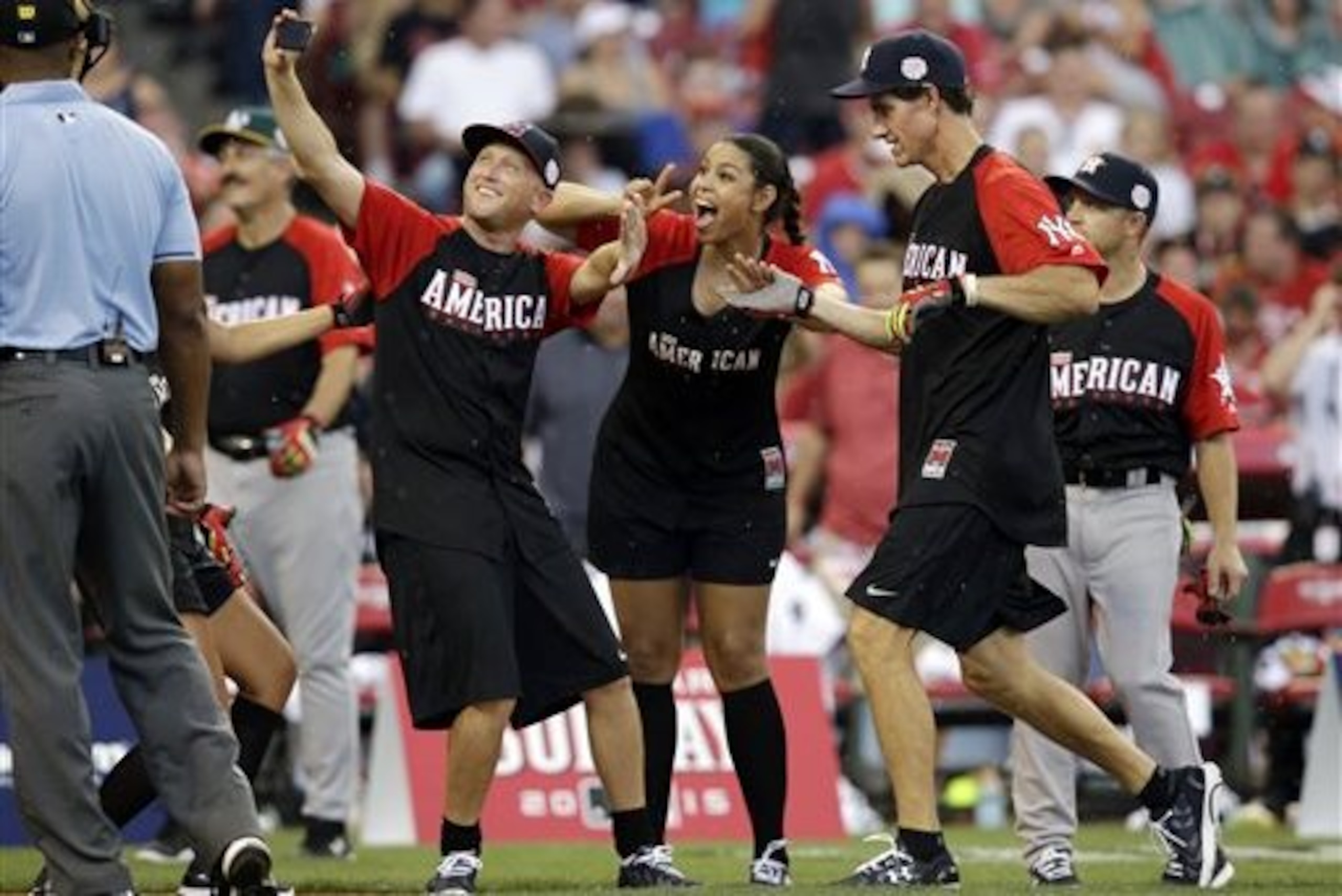 Paul O’Neill celebrates with his teammates after hitting a home run during the All-Star Legends & Celebrity Softball game, Sunday, July 12, 2015, in Cincinnati. (AP Photo/John Minchillo)