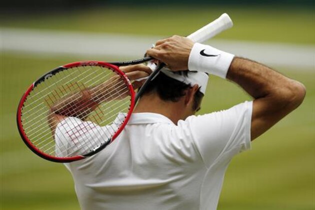 Roger Federer of Switzerland adjusts his headband during his men's semifinal singles match against Milos Raonic of Canada on day twelve of the Wimbledon Tennis Championships in London, Friday, July 8, 2016. (AP Photo/Alastair Grant)