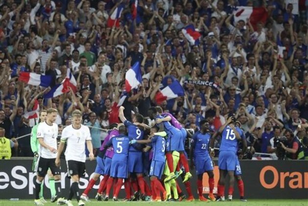 France's Antoine Griezmann, covered by his teammates, celebrates after scoring during the Euro 2016 semifinal soccer match between Germany and France, at the Velodrome stadium in Marseille, France, Thursday, July 7, 2016. (AP Photo/Petr David Josek)