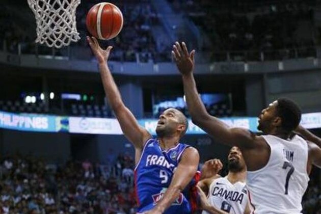 Tony Parker of France scores on a lay-up over Canada's Melvin Ejim (7) and Thomas Scrubb during their finals basketball match in the FIBA Olympic Qualifying tournament Sunday, July 10, 2016 at the Mall of Asia Arena in suburban Pasay city south of Manila, Philippines. (AP Photo/Bullit Marquez)