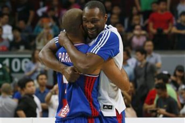 Tony Parker and Florent Pietrus, right, of France celebrate following their win over Canada in the finals of the FIBA Olympic Qualifying basketball match Sunday, July 10, 2016 at the Mall of Asia Arena in suburban Pasay city south of Manila, Philippines. France won 83-74 to qualify for the Rio Olympics. (AP Photo/Bullit Marquez)