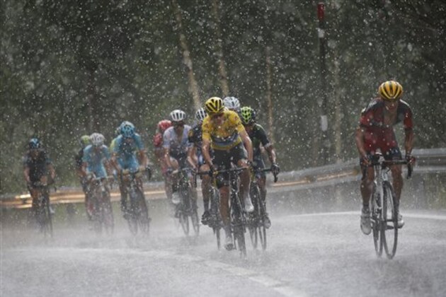 Australia’s Richie Porte, right, breaks away from the group with Britain's Chris Froome, wearing the overall leader's yellow jersey, as they climb towards Andorra Arcalis in pouring rain and hail during the ninth stage of the Tour de France cycling race over 184.5 kilometers (114.3 miles) with start in Vielha Val d'Aran, Spain, and finish in Andorra Arcalis, Andorra, Sunday, July 10, 2016. (AP Photo/Christophe Ena)
