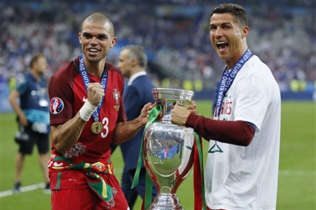 Portugal's Cristiano Ronaldo, right, and Pepe celebrate with the trophy at the end of the Euro 2016 final soccer match between Portugal and France at the Stade de France in Saint-Denis, north of Paris, Sunday, July 10, 2016. Portugal won 1-0. (AP Photo/Frank Augstein)