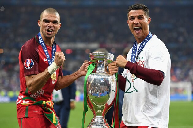 PARIS, FRANCE - JULY 10:  Cristiano Ronaldo (R) and Pepe (L) of Portugal pose for photographs holding the Henri Delaunay trophy to celebrate after their 1-0 win against France in the UEFA EURO 2016 Final match between Portugal and France at Stade de France on July 10, 2016 in Paris, France.  (Photo by Laurence Griffiths/Getty Images)