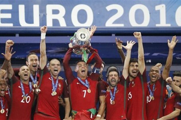Portugal's Cristiano Ronaldo, center, and teammates with the trophy after the Euro 2016 final soccer match between Portugal and France at the Stade de France in Saint-Denis, north of Paris, Sunday, July 10, 2016. (AP Photo/Frank Augstein)