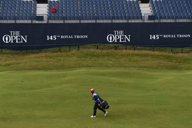 A caddie walks down the 18th fairway during practice on July 11, 2016, ahead of the 2016 British Open Golf Championship at Royal Troon in Scotland.
The 2016 British Open begins on July 14, 2016. The British Open returns to Royal Troon on Scotland's west coast this week with Rory McIlroy back in the field having been unable to defend the Claret Jug a year ago due to injury. / AFP / BEN STANSALL / RESTRICTED TO EDITORIAL USE        (Photo credit should read BEN STANSALL/AFP/Getty Images)