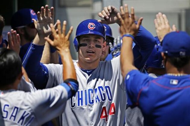 Chicago Cubs' Anthony Rizzo, center, celebrates in the dugout after scoring one of two runs on a single by Cubs' Addison Russell off Pittsburgh Pirates starting pitcher Jonathon Niese in the first inning of a baseball game in Pittsburgh, Sunday, July 10, 2016. (AP Photo/Gene J. Puskar)