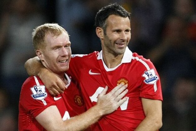 FILE - This is a Monday, Aug. 16, 2010 file photo Manchester United's Ryan Giggs, right,  with teammate Paul Scholes after scoring a goal against Newcastle United during their English Premier League soccer match at Old Trafford, Manchester, England.  Ryan Giggs will be assisted by former teammates Paul Scholes, Nicky Butt and Phil Neville during his spell as interim manager of Manchester United following the dismissal of David Moyes. (AP Photo/Tim Hales, File)