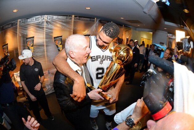 SAN ANTONIO, TX - JUNE 15: Head Coach Gregg Popovich and Tim Duncan #21 of the San Antonio Spurs celebrate in the locker room with the Larry O'Brien trophy after defeating the Miami Heat to win the 2014 NBA Finals in Game Five of the 2014 NBA Finals on June 15, 2014 at AT&T Center in San Antonio, Texas. NOTE TO USER: User expressly acknowledges and agrees that, by downloading and or using this photograph, User is consenting to the terms and conditions of the Getty Images License Agreement. Mandatory Copyright Notice: Copyright 2014 NBAE (Photo by Jesse D. Garrabrant/NBAE via Getty Images)
