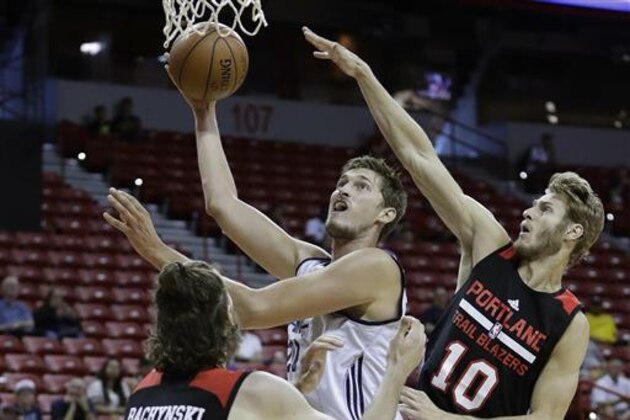 Utah Jazz's Tibor Pleiss, center, shoots over Portland Trail Blazers' Jordan Bachynski, left, and Jake Layman during the second half of an NBA summer league basketball game Wednesday, July 13, 2016, in Las Vegas. (AP Photo/John Locher)
