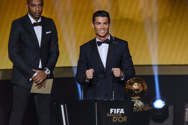 Real Madrid and Portugal forward Cristiano Ronaldo (R) reacts next to French former star player Thierry Henry (L) after receiving the 2014 FIFA Ballon d'Or award for player of the year during the FIFA Ballon d'Or award ceremony at the Kongresshaus in Zurich on January 12, 2015. AFP PHOTO / FABRICE COFFRINI        (Photo credit should read FABRICE COFFRINI/AFP/Getty Images)
