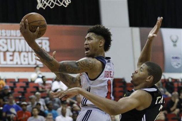 Washington Wizards' Kelly Oubre Jr., left, shoots around Atlanta Hawks' Edy Tavares during the first half of an NBA summer league basketball game, Sunday, July 10, 2016, in Las Vegas. (AP Photo/John Locher)