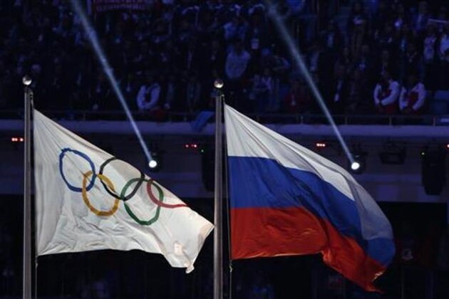 FILE- In this Feb. 23, 2014, file photo, the Russian national flag, right, flies after next to the Olympic flag during the closing ceremony of the 2014 Winter Olympics in Sochi, Russia. The World Anti-Doping Agency commissioned an investigation, being headed by Richard McLaren, into Russian doping following a New York Times story in May that detailed a state-run system that helped athletes get away with cheating and win medals at the Sochi Olympics in 2014. The McLaren report is due Friday, July 15, 2016, with public release set for next Monday. (AP Photo/Matthias Schrader, File)
