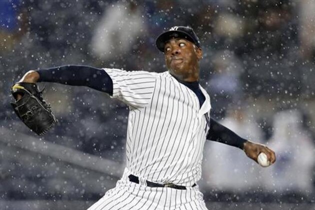 New York Yankees relief pitcher Aroldis Chapman winds up in a heavy rain during the ninth inning of a baseball game against the Texas Rangers in New York, Monday, June 27, 2016. The umpires decided to call a rain delay with one Ranger runner on base and Shin-Soo Choo at the plate in a 6-5 game with the Yankees leading. (AP Photo/Kathy Willens)