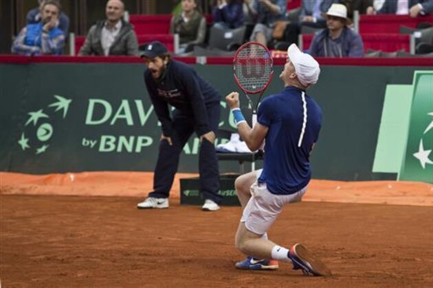 Britain's Kyle Edmund, front, drops to his knees in celebration after having won his Davis Cup quarterfinal tennis match against Serbia's Dusan Lajovic in Belgrade, Serbia, Sunday, July 17, 2016. Britain advanced to the Davis Cup semifinals after having defeated Serbia in Belgrade. (AP Photo/Marko Drobnjakovic)