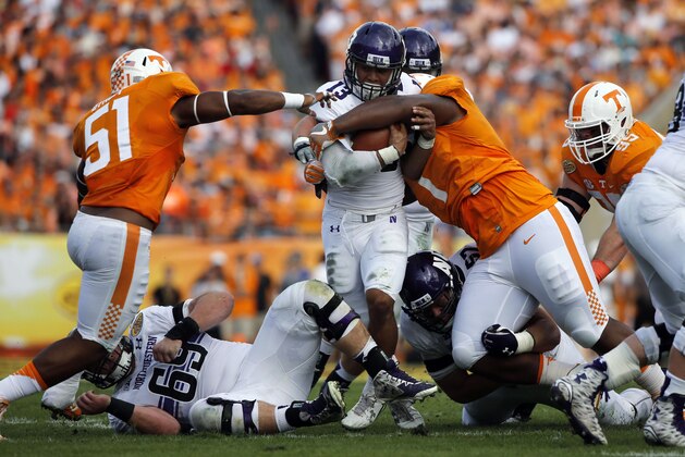 Jan 1, 2016; Tampa, FL, USA; Northwestern Wildcats running back Warren Long (13) runs with the ball as Tennessee Volunteers defensive lineman Kahlil McKenzie (1) and Tennessee Volunteers linebacker Kenny Bynum (51) defend and during the first half in the 2016 Outback Bowl at Raymond James Stadium. Mandatory Credit: Kim Klement-USA TODAY Sports