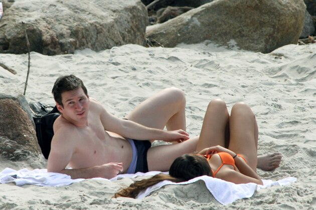 Argentine football star and player of Spain's Barcelona FC Lionel Messi (L) and his girlfriend Antonella Roccuzzo sunbathe in a beach in Rio de Janeiro on July 9, 2010. Messi is enjoying some holidays after his team was knocked out of the FIFA World Cup South Africa 2010. AFP PHOTO/Gabriel Reis (Photo credit should read GABRIEL REIS/AFP/Getty Images)