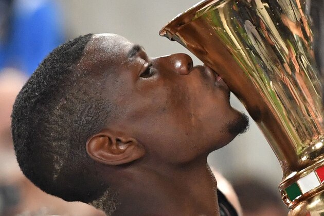 Juventus' midfielder from France Paul Pogba kisses the trophy after winning the Italian Tim Cup final football match AC Milan vs Juventus on May 21, 2016 at the Olympic Stadium in Rome.  Juventus won 0-1 in the extra time.     AFP PHOTO / TIZIANA FABI / AFP / TIZIANA FABI        (Photo credit should read TIZIANA FABI/AFP/Getty Images)