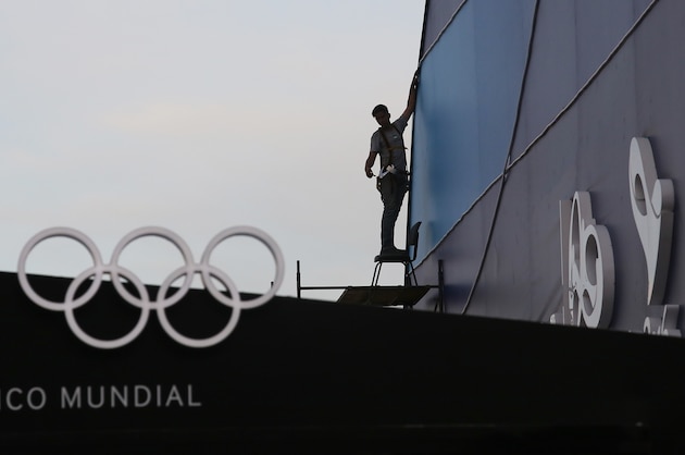 RIO DE JANEIRO, BRAZIL - JULY 14:  A man works near a display of Olympic rings at the official Olympics megastore on Copacabana beach on July 14, 2016 in Rio de Janeiro, Brazil. The Rio 2016 Olympic Games commence August 5th and Copacabana is one of the major venue locations.  (Photo by Mario Tama/Getty Images)