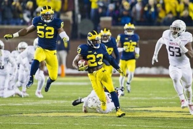 Michigan wide receiver Dennis Norfleet (23) escapes tackles on a kickoff return in the third quarter of an NCAA college football game against Maryland in Ann Arbor, Mich., Saturday, Nov. 22, 2014. The play was nullified due to a Michigan penalty. Maryland won 23-16. (AP Photo/Tony Ding)