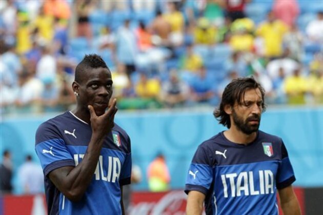 Italy's Mario Balotelli, left, and Andrea Pirlo warm up prior to the group D World Cup soccer match between Italy and Uruguay at the Arena das Dunas in Natal, Brazil, Tuesday, June 24, 2014. (AP Photo/Antonio Calanni)