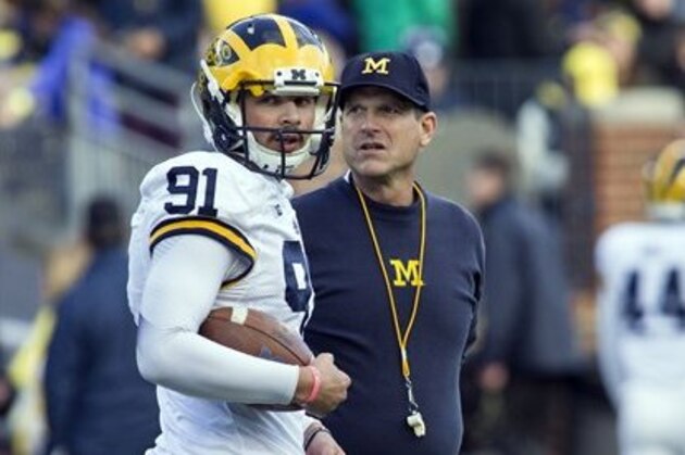 Michigan kicker Kenny Allen (91) talks with Michigan head coach Jim Harbaugh on the field before the NCAA college football team's annual Spring Game at Michigan Stadium in Ann Arbor, Mich., Friday, April 1, 2016. (AP Photo/Tony Ding)