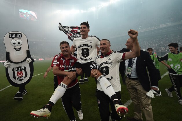 Besiktas's German forward Mario Gomez (C) celebrates with his team the 2015-2016 champion title after winning the Turkish Super Toto league football match between Besiktas and Osmanlispor at the Vodafone arena Stadium in Istanbul on May 15, 2016. / AFP / OZAN KOSE        (Photo credit should read OZAN KOSE/AFP/Getty Images)