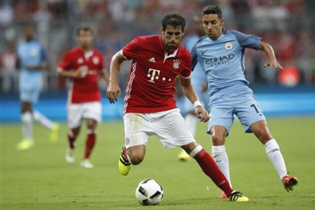 Bayern's Javi Martinez, left, and Manchester City's Jesus Navas challenge for the ball during a friendly soccer match between FC Bayern Munich and Manchester City at the Allianz Arena stadium in Munich, Germany, Wednesday, July 20, 2016. (AP Photo/Matthias Schrader)