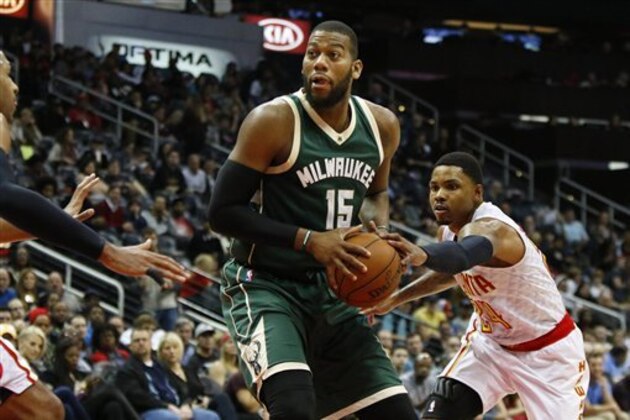 Milwaukee Bucks center Greg Monroe (15) is guarded by Atlanta Hawks' Al Horford (15) and Kent Bazemore (24) in the second half of an NBA basketball game, Saturday, Feb. 20, 2016, in Atlanta. Milwaukee won 117-109 in double overtime. (AP Photo/Brett Davis)