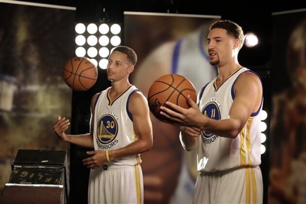 Golden State Warriors' Stephen Curry, left, and Klay Thompson (11) pose for photographs during an NBA basketball media day Monday, Sept. 28, 2015, in Oakland, Calif. (AP Photo/Ben Margot)