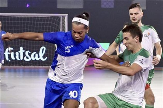 In this Sunday,  July 17, 2016 photo, Brazilian soccer player Ronaldinho, left, playing for Goa 5s, vies for the ball against a player of Bengaluru 5s during a match of the Premier Futsal tournament in Chennai, India. Six teams are participating in the first year of the tournament in India. (R Senthil Kumar/Press Trust of India via AP)