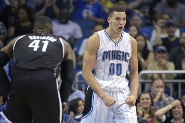Aaron Gordon, alero del Magic de Orlando, festeja luego de realizar una clavada frente a Thomas Robinson, de los Nets de Brooklyn, en el partido realizado el martes 29 de marzo de 2016 (AP Foto/Phelan M. Ebenhack)