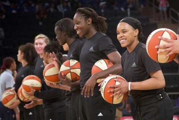 FILE - In this Wednesday, July 13, 2016 file photo, members of the New York Liberty basketball team await the start of a game against the Atlanta Dream, in New York. The WNBA has fined the New York Liberty, Phoenix Mercury and Indiana Fever and their players for wearing plain black warm-up shirts in the wake of recent shootings by and against police officers. All three teams were fined $5,000 and each player was fined $500. While the shirts were the Adidas brand - the official outfitter of the league - WNBA rules state that uniforms may not be altered in any way. (AP Photo/Mark Lennihan, File)