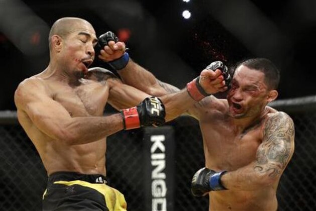Jose Aldo, left, and Frankie Edgar trade blows during their featherweight championship mixed martial arts bout at UFC 200, Saturday, July 9, 2016, in Las Vegas. (AP Photo/John Locher)