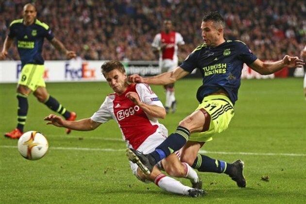 Ajax's Joel Veltman blocks a shot by Fenerbahce’s Robin van Persie, right, during the Europa League group A soccer match between Ajax and Fenerbahce at the ArenA stadium in Amsterdam, Netherlands, Thursday, Nov. 5, 2015. (AP Photo/Peter Dejong)