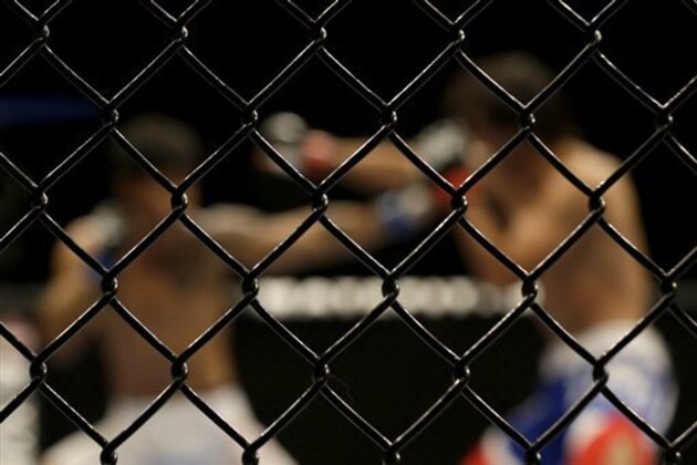 The octagon cage is shown as Tiago Trator, left, fights Akbarh Arreola during a lightweight mixed martial arts bout at a UFC on Fox event in San Jose, Calif., Saturday, July 26, 2014. Trator won by unanimous decision. (AP Photo/Jeff Chiu)