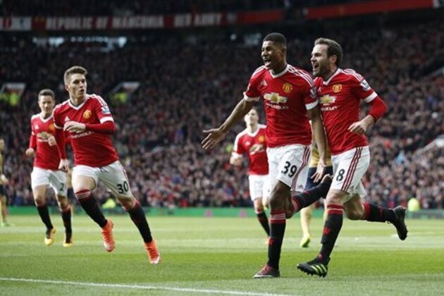 Manchester United's Marcus Rashford, second right, celebrates with teammate Juan Mata after he sores the opening goal of the game during the English Premier League soccer match between Manchester United and Arsenal at Old Trafford Stadium, Manchester, England, Sunday, Feb. 28, 2016. (AP Photo/Jon Super)